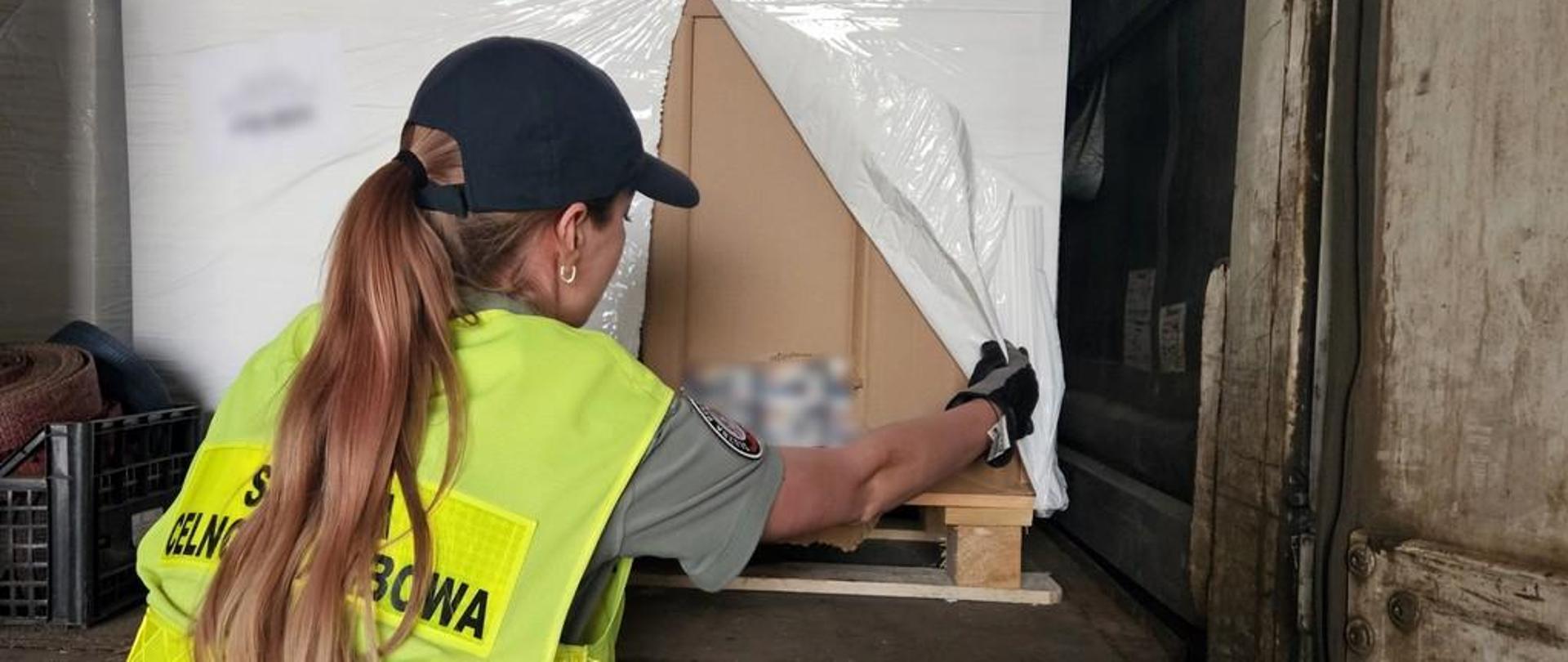 Funkcjonariuszka KAS podczas sprawdzania ładunku.