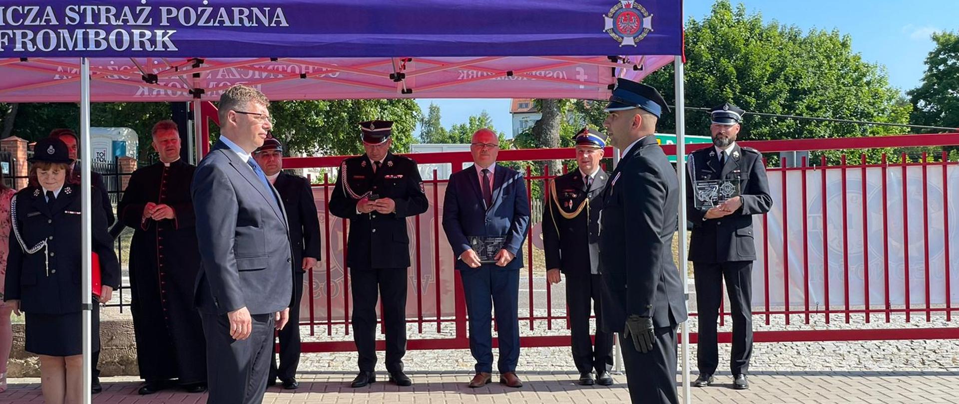 Strażak składa meldunek wojewodzie