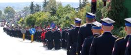 Uczestnicy obchodów idą podczas uroczystości pogrzebowej.