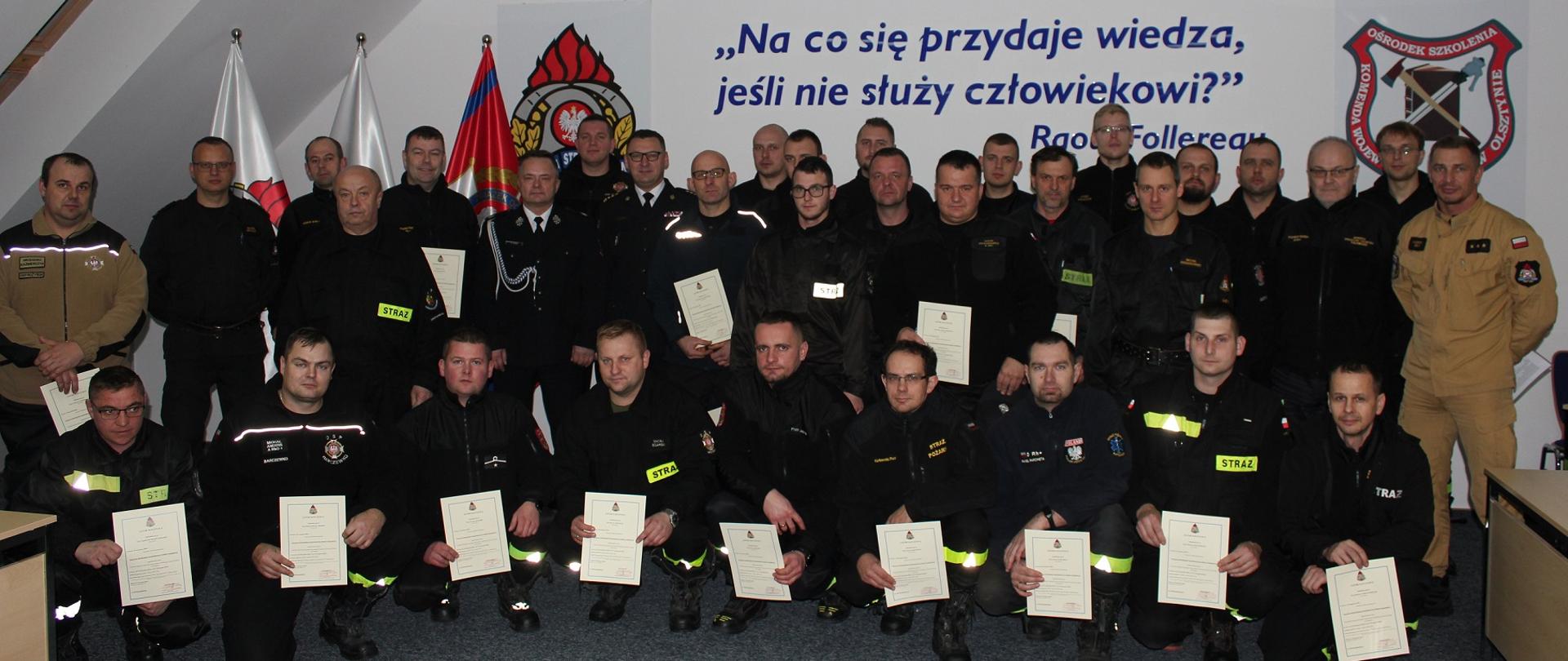 Druhowie w mundurach koszarowych z dyplomami świadczącymi o ukończeniu kursu naczelników OSP