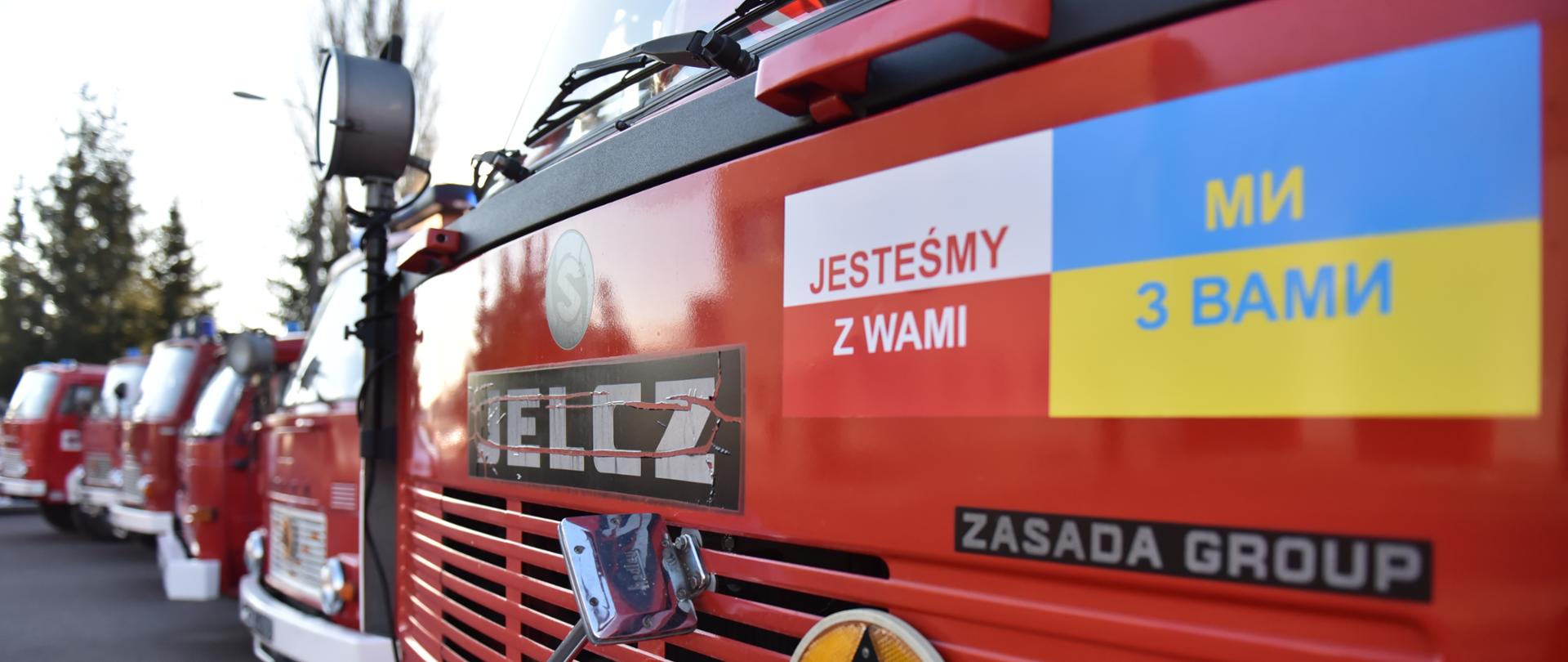 Na zdjęciu maska samochodu gaśniczego jelcz w tle maski kolejnych pięciu samochodów gaśniczych