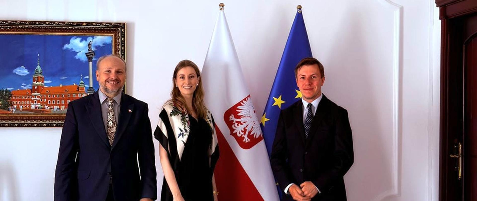 Zdjęcie p. Kamil Jagodziński i p. Piotr Kuchta z p. Marią Szymanowską na tle flag