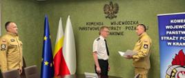 Powierzenie obowiązków naczelnika wydziału kontrolno-rozpoznawczego na sali KW PSP w Krakowie, MKW PSP wręcza nowemu naczelnikowi decyzję kadrową, po lewej stoi zastępca MKW PSP