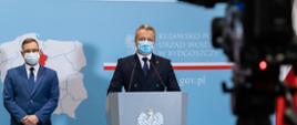 Wojewoda Kujawsko-Pomorski Mikołaj Bogdanowicz przemawia podczas konferencji, obok niego pełnomocnik wojewody do spraw szczepień Krzysztof Poskrop
