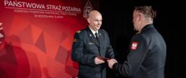 Komendant powiatowy wręcza wyróżnienie strażakowi który podczas wypadku drogowego udzielał pomocy poszkodowanym w czasie wolnym od służby