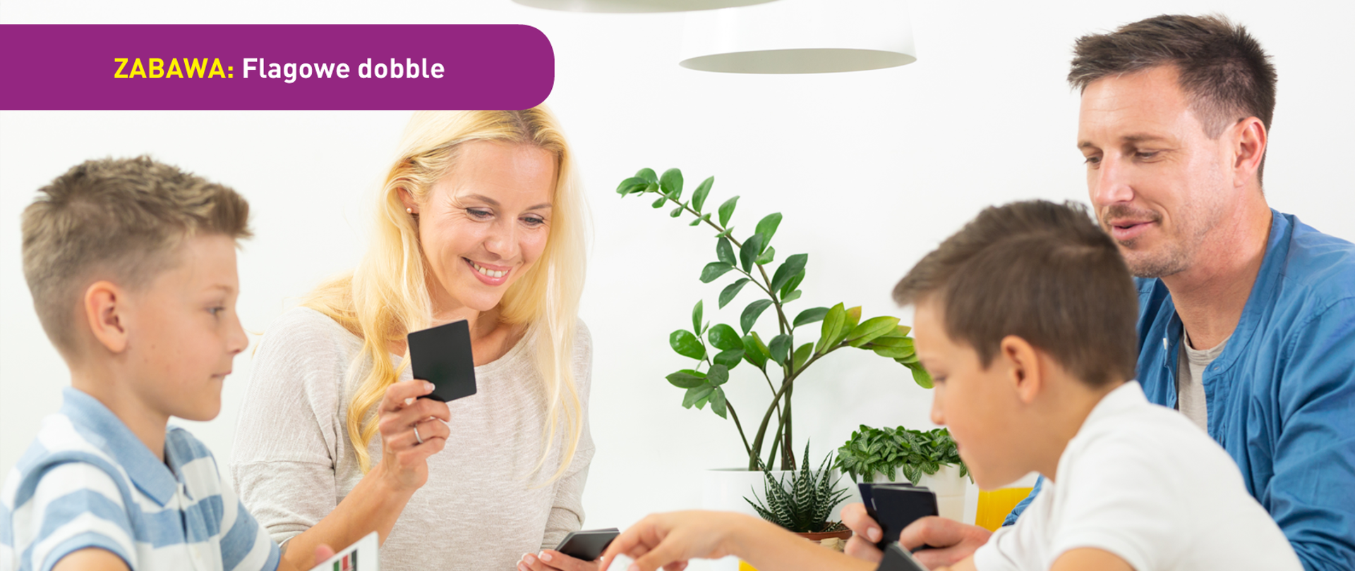 Na zdjęciu widać dwóch chłopców i dwoje dorosłych, prawdopodobnie rodzinę, grającą w grę karcianą przy stole. U dołu znajduje się pasek logotypów: Europejskie Fundusze Polska Cyfrowa, Ministerstwo Cyfryzacji, NASK i Unia Europejska Europejski Fundusz Rozwoju Regionalnego.