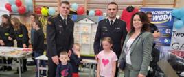 Strażacy przy mobilnym symulatorze z dziećmi oraz wicewojewodą