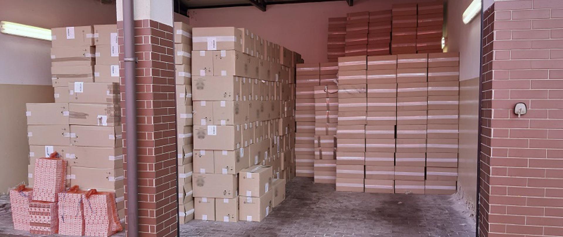 Nielegalne papierosy w pudełkach ułożone w magazynie.