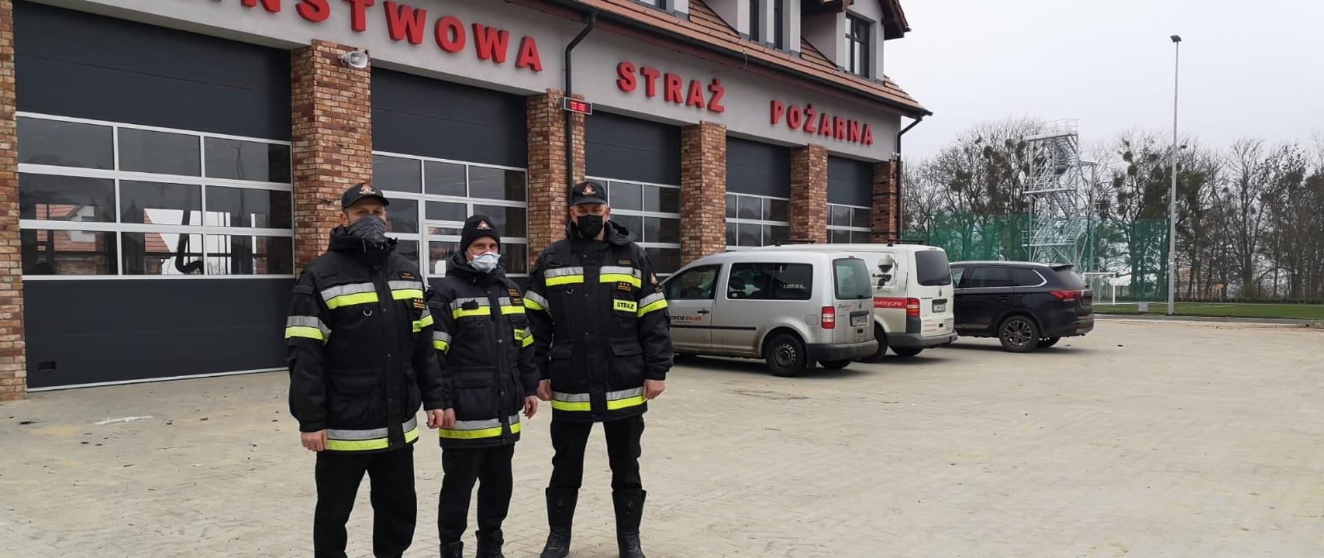 st. bryg. Sławomir Herbowski, st. bryg. Piotr Tkaczyński oraz st. bryg. Andrzej Rafalski w umundurowaniach dowódczo-sztabowych na tle budynku nowej komendy.