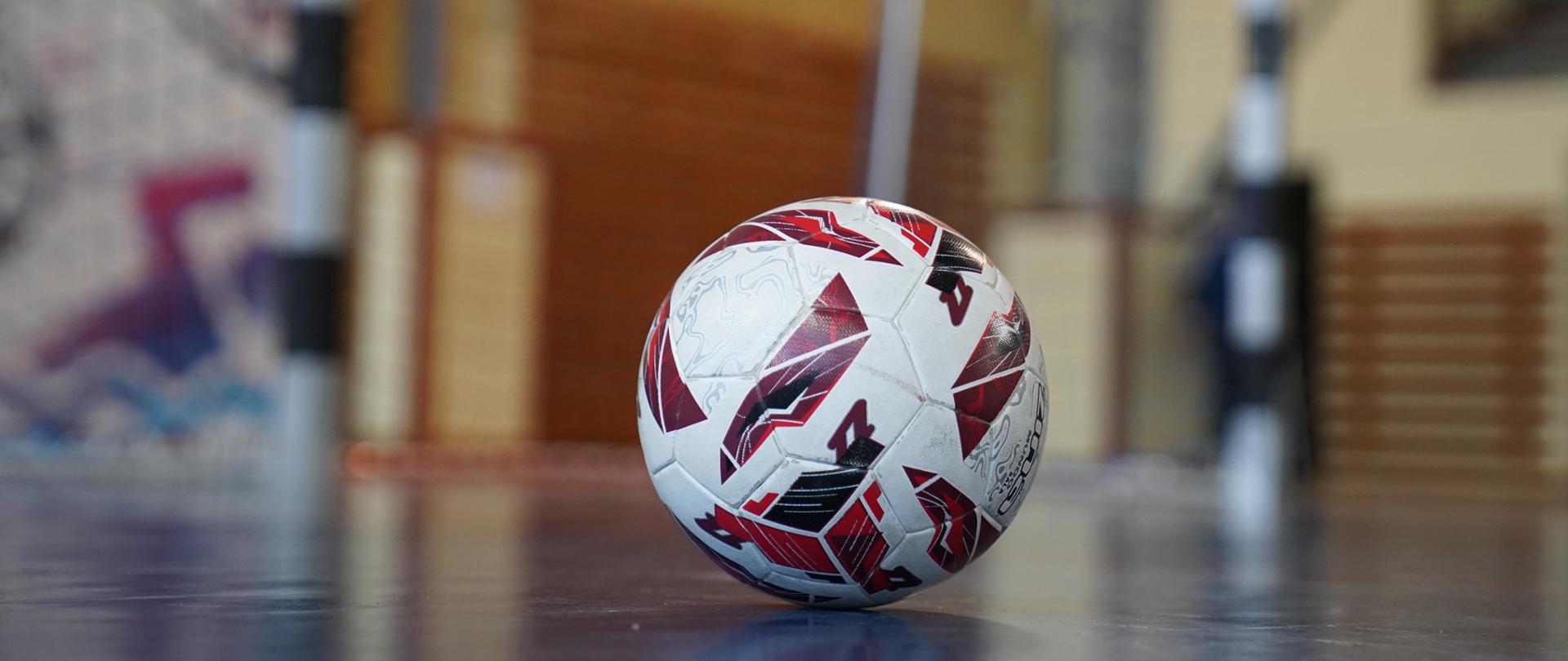 Widok piłki stojącej na parkiecie hali sportowej 