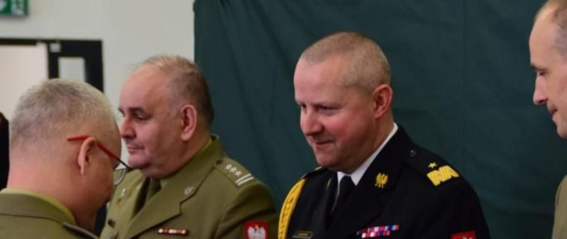 strażak stoi na baczność przed nim mężczyzna w mundurze wojskowym