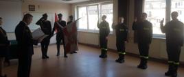 ślubowanie funkcjonariuszy na świetlicy JRG 1 w Gdańsku, w tle poczet sztandarowy