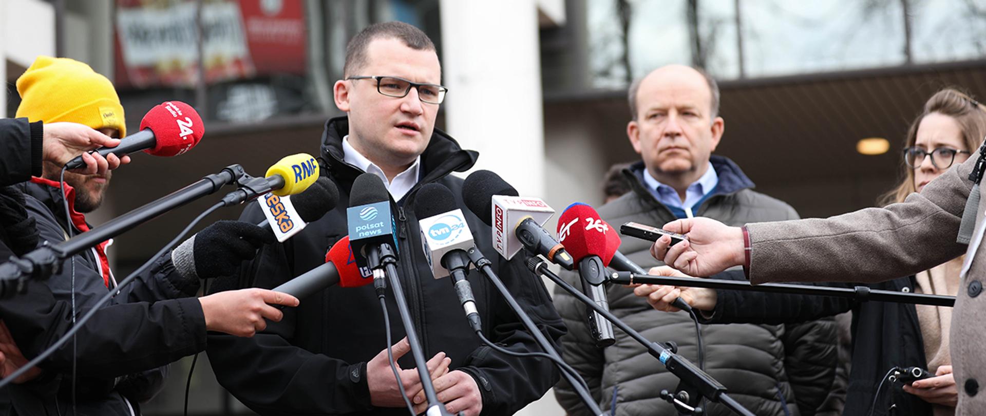 Na zdjęciu widoczny wiceminister Paweł Szefernaker podczas wypowiedzi dla mediów.