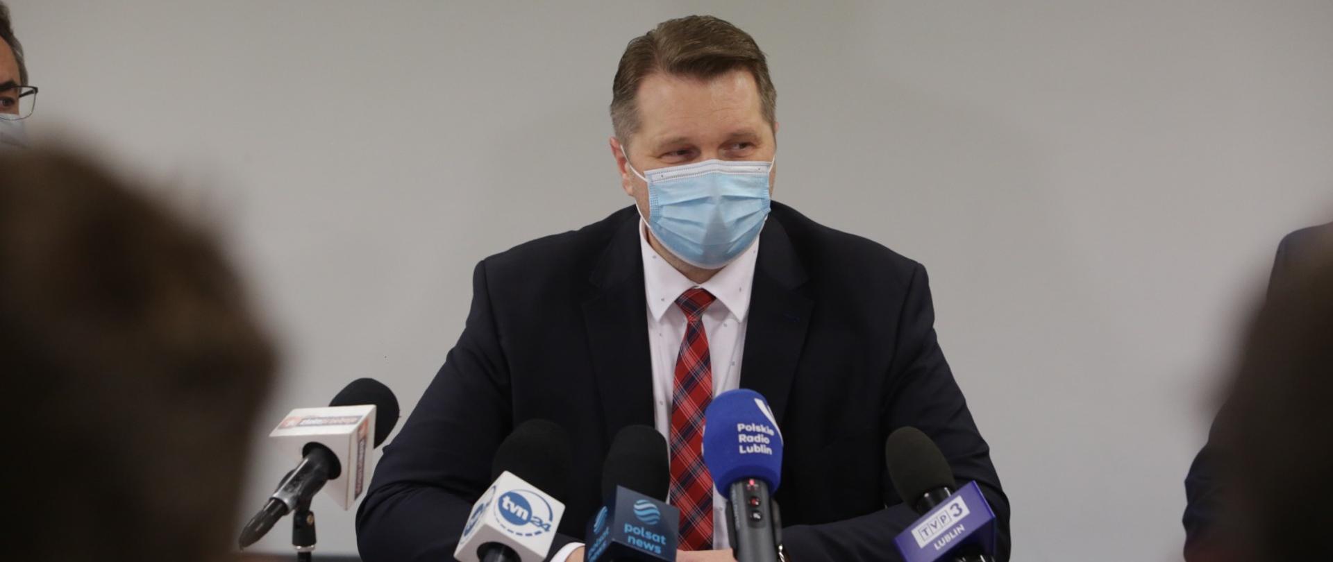 konferencja prasowa z udziałem ministra czarnka po przyjęciu szczepionki w szpitalu w Lublinie. minister odpowiada do mikrofonu na siedząco na pytania dziennikarzy 