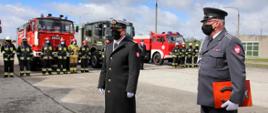 Na zdjęciu widać strażaków OSP, strażaków Wojskowej Straży Pożarnej stojących przy pojazdach pożarniczych oraz dowództwo wojskowe podczas podsumowania ćwiczeń.