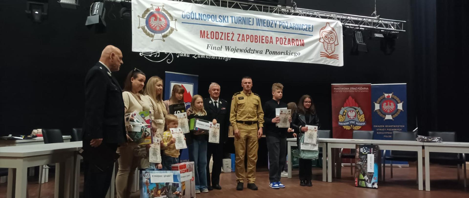 Na zdjęciu widać wręczenie nagród w jednej z kategorii. Obecni na miejscu przedstawiciele szczebla wojewódzkiego z PSP oraz OSP