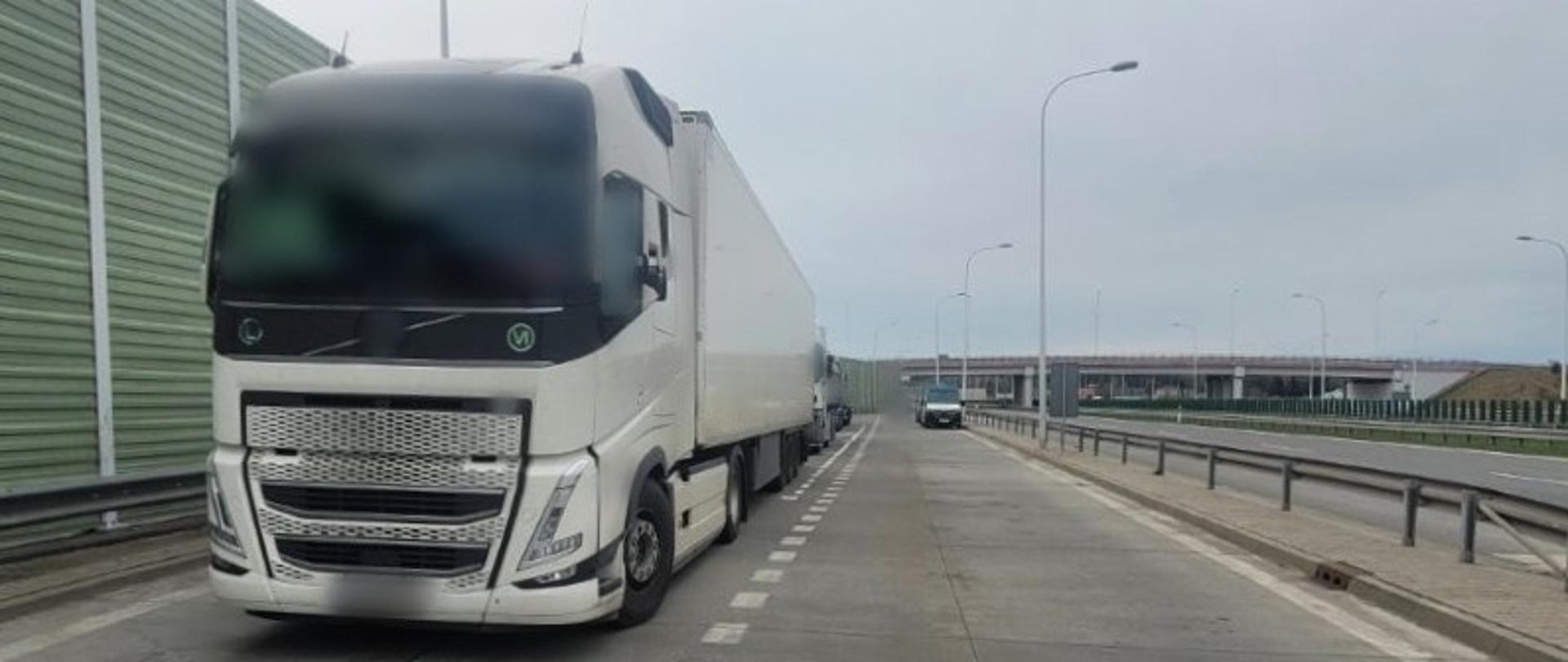 Na pierwszym planie (od lewej): ciągnik siodłowy z podpiętą naczepą. Za nim stoją dwa inne zestawy ciężarowe. W tle: oznakowany furgon mazowieckiej Inspekcji Transportu Drogowego.