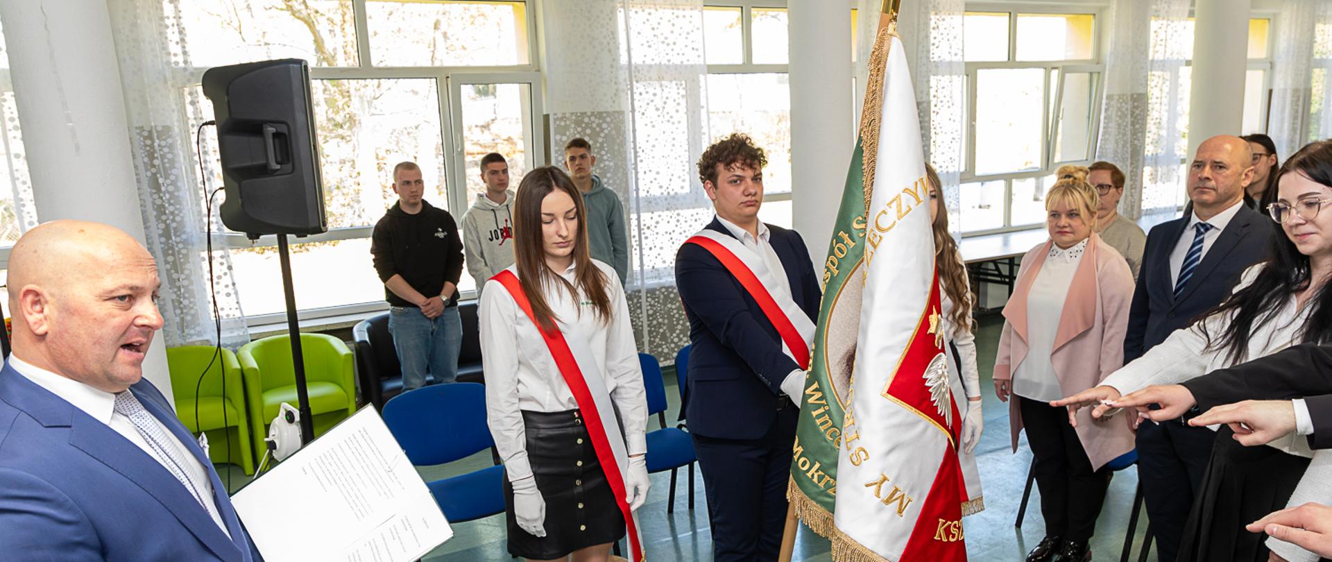 uczniowie wokół sztandaru szkoły podczas ceremonii ślubowania absolwentów