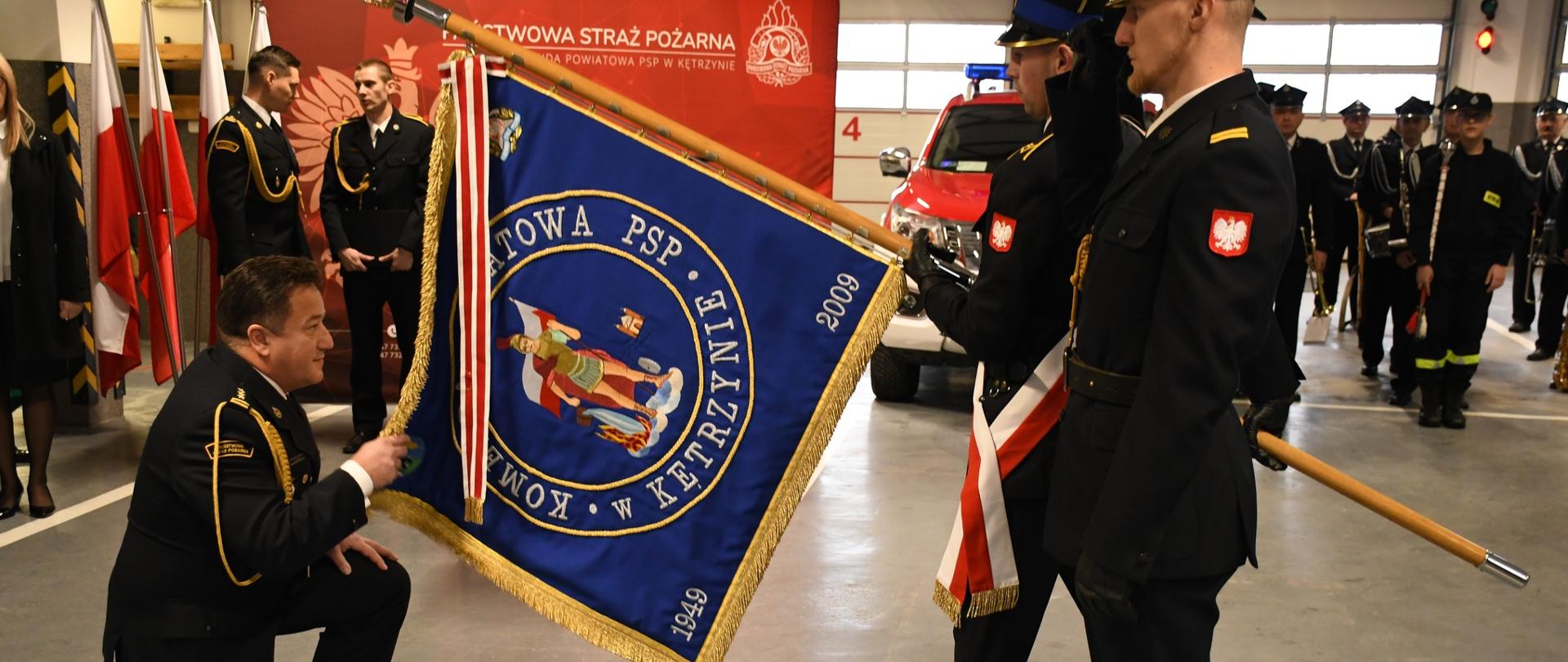 Komendant Powiatowy PSP w Kętrzynie st. bryg. Tomasz Syguła zdaje obowiązki poprzez ucałowanie sztandaru Komendy.