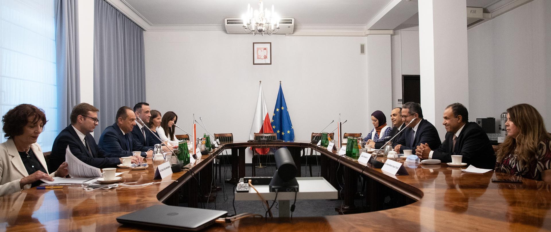 spotkanie przy stole owalnym , w tle flagi