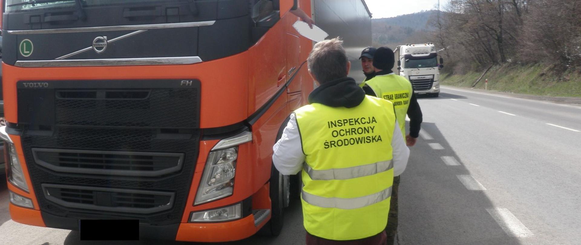 Inspektorzy kontrolują samochód na drodze pod kątem przewożenia odpadów.