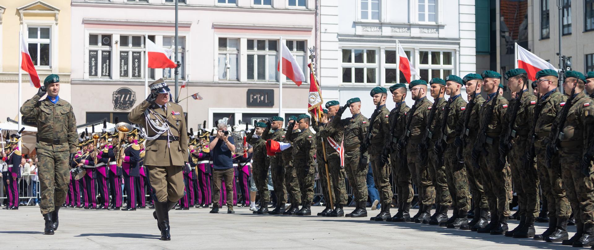 Generał brygady Piotr Wagner oddaje honory sztandarowi.
