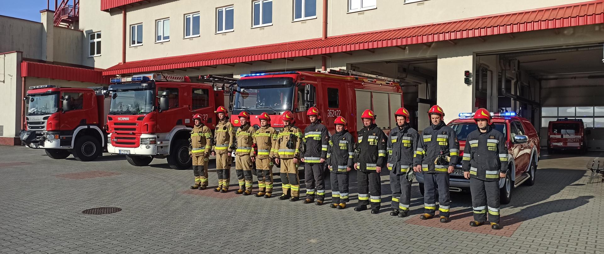 Strażacy stoją w szeregu przed garażem