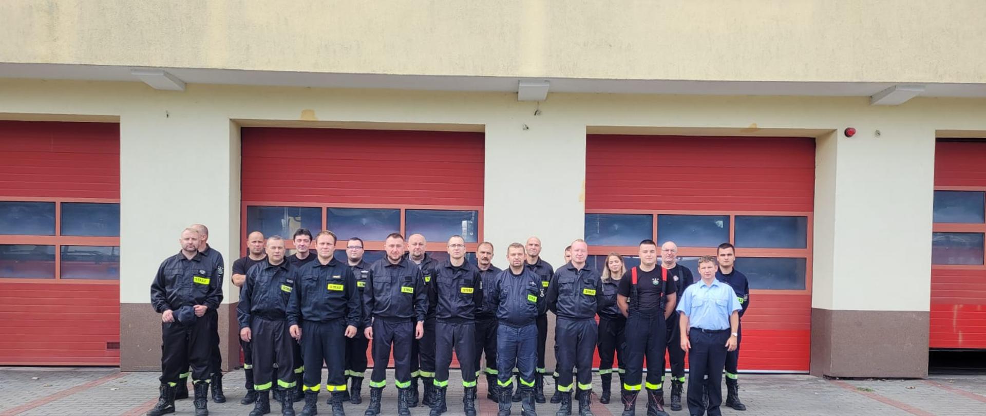 na tle JRG w Sztumie stoją absolwenci kursu konserwatorów-kierowców OSP.