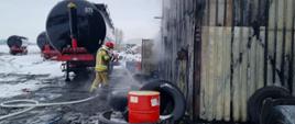 Strażak chłodzący zbiorniki wydobyta z pomieszczenia objętego pożarem