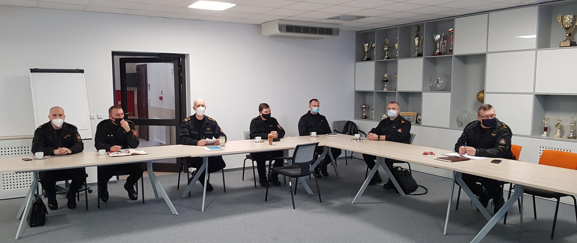 Na zdjęciu strażacy siedzą na odprawie