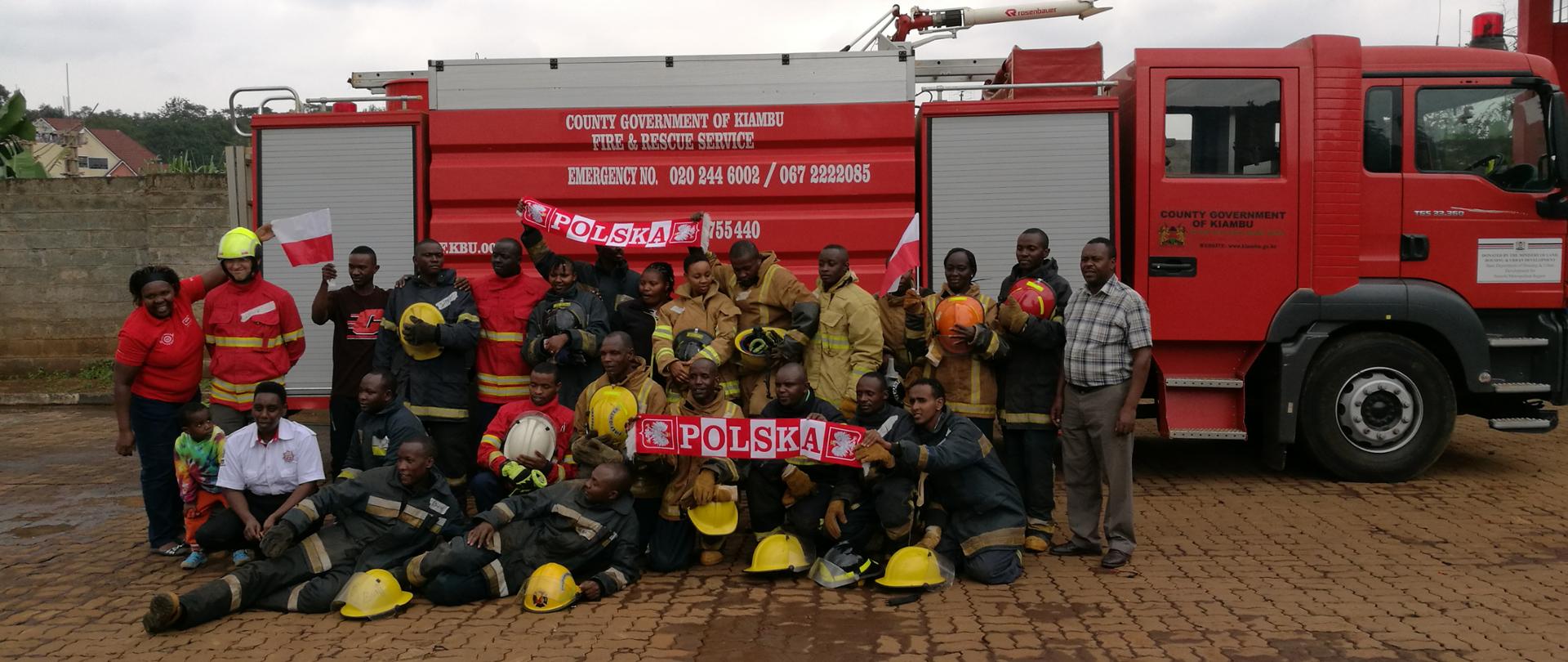 Zdjęcie grupowe strażaków kenijskich na tle wozu strażackiego