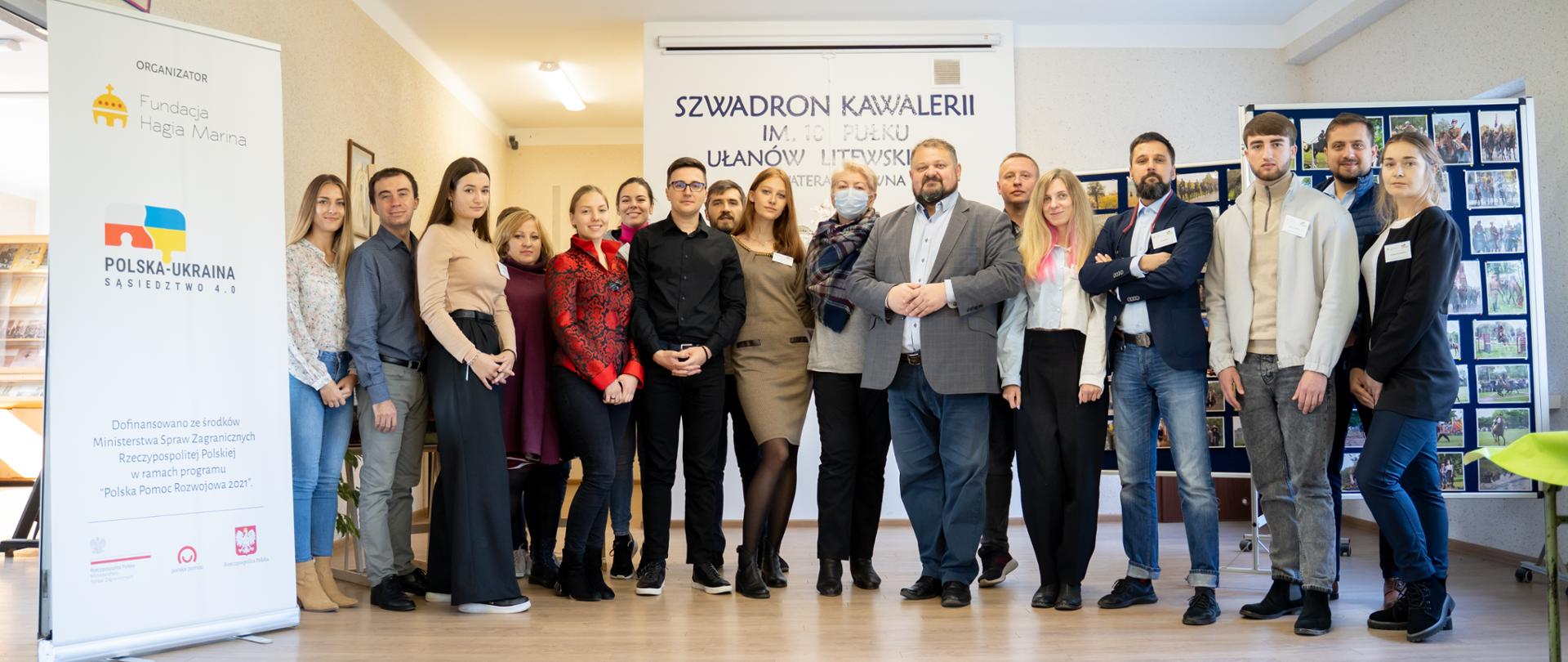 Grupa ludzi pozuje przy rolapach z logiem Polska-Ukraina Sąsiedztwo.