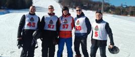 Na zdjęciu pięciu narciarzy pozujących na stoku narciarskim