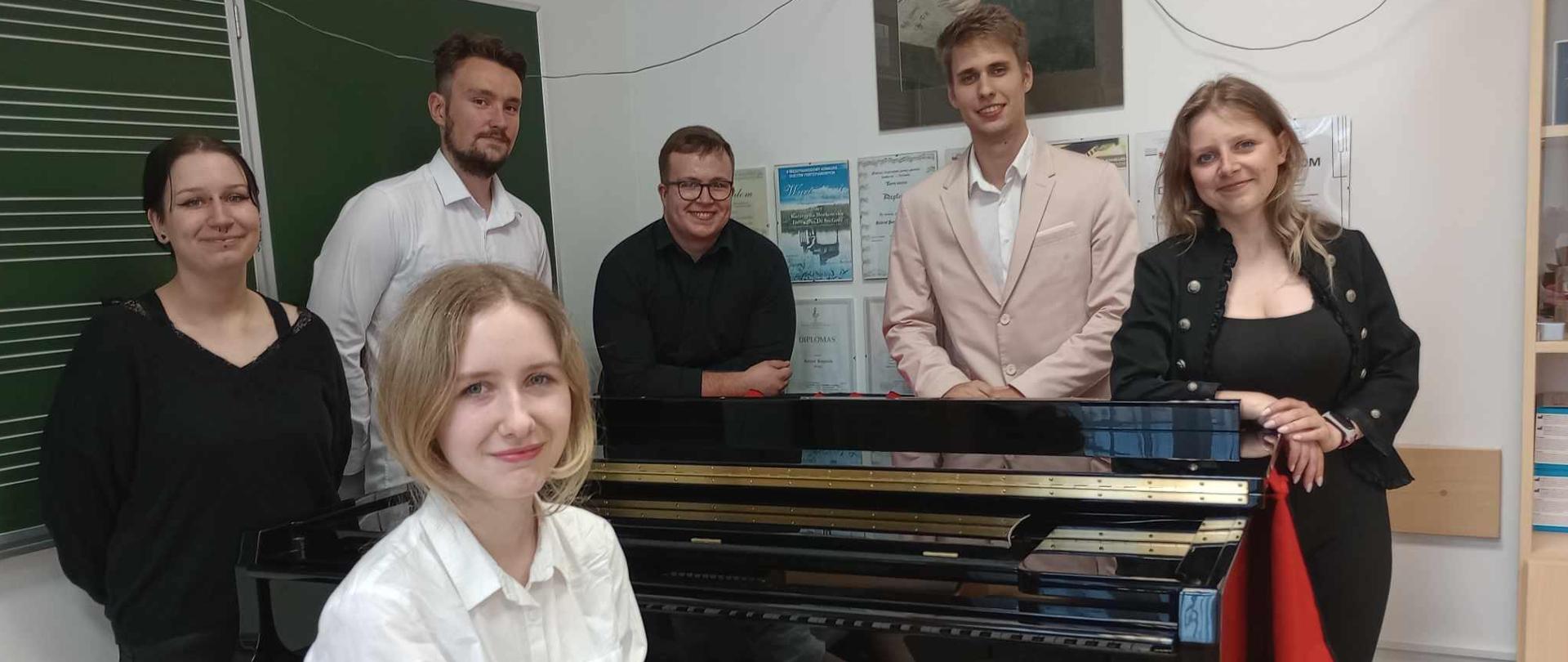Zdjęcie sześciu osób przy fortepianie, trzy dziewczyny i trzech chłopaków.