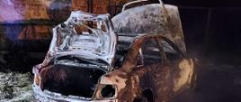 Zdjęcie przedstawia samochód osobowy marki Audi, który uległ całkowitemu spaleniu.