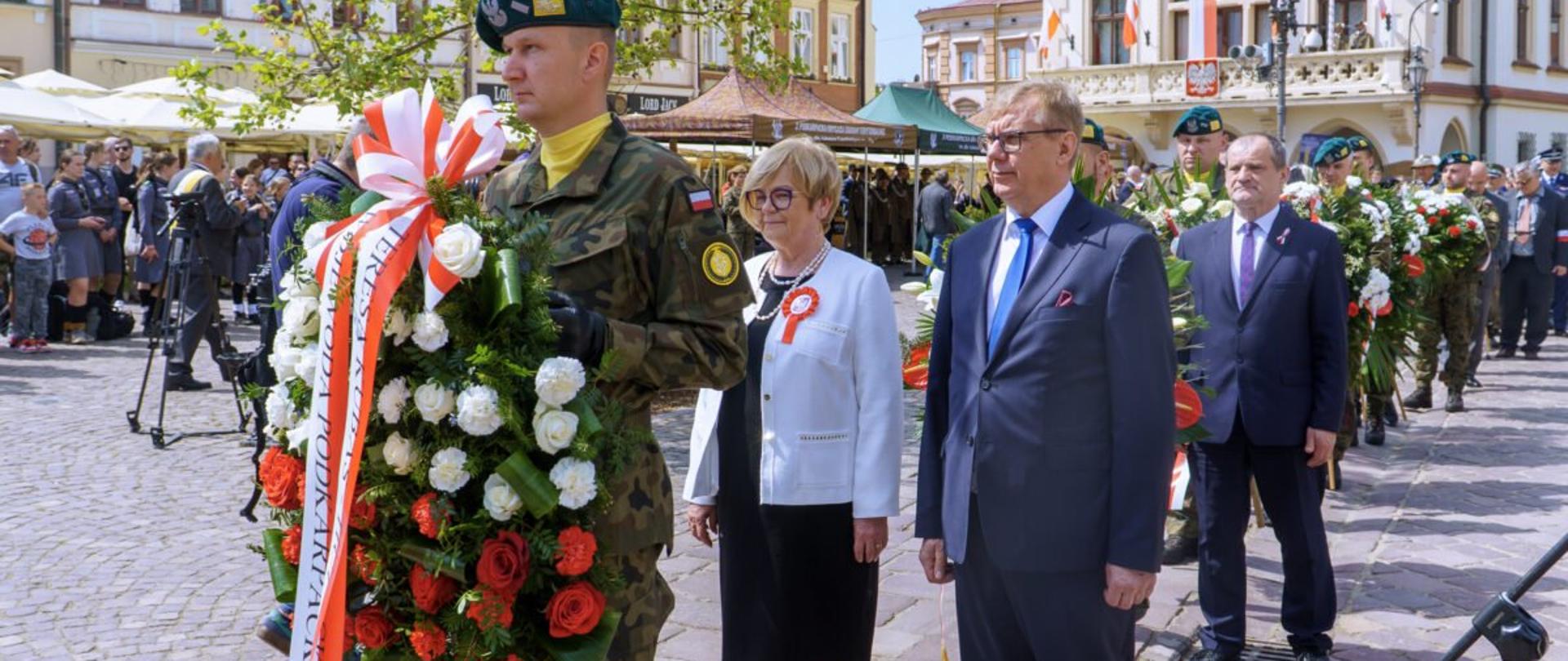 Zdjęcie przedstawia żołnierza z wieńcem, za nim wojewoda podkarpacki Teresa Kubas-Hul i dyrektor generalny Podkarpackiego Urzędu Wojewódzkiego w Rzeszowie Tomasz Cyran