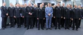 Na zdjęciu widać strażaków którzy brali udział w akcji gaszenia pożarów lasów we Francji w mundurach wyjściowych ustawionych obok siebie na sali konferencyjnej, oraz komendanta głównego PSP gen. brygadiera Andrzeja Bartkowiaka wraz z zastępcami, komendantami województw dolnośląskiego, zachodniopomorskiego i wiceministra SWiA Macieja Wąsika ustawionych razem do zdjęcia grupowego. 
