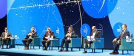 Wiceminister rozwoju i technologii Andrzej Gut-Mostowy podczas panelu "Turystyka - nowe otwarcie" na Europejskim Kongresie Gospodarczym w Katowicach, wiceminister siedzi w fotelu, po jego lewej stronie pozostali uczestnicy debaty