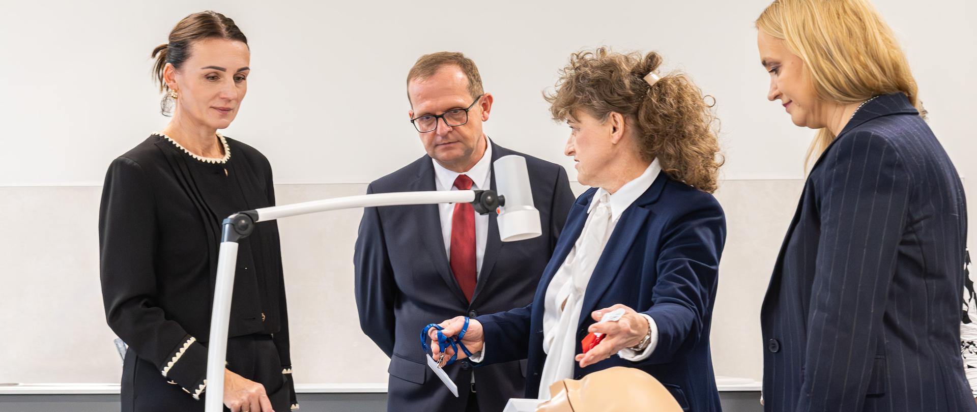 kilka osób ogląda fantomy stomatologiczne