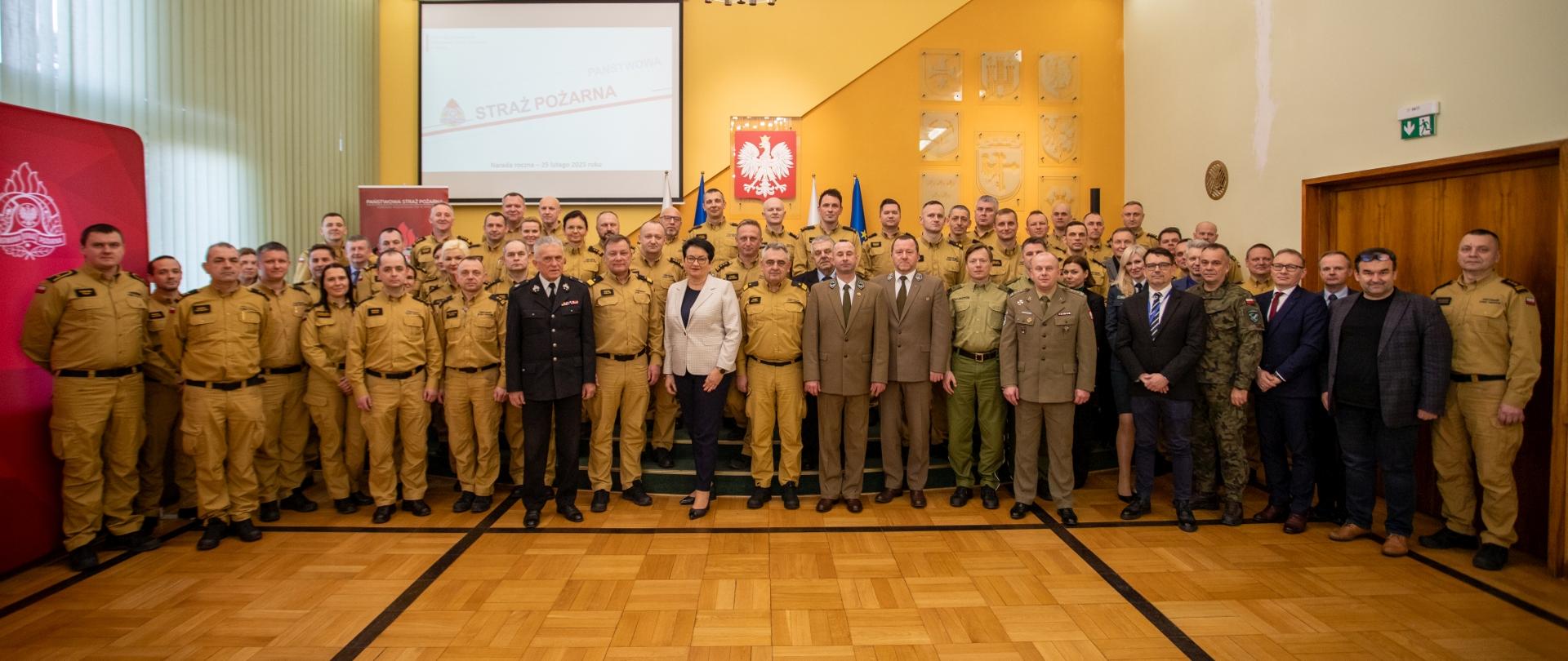 Uczestnicy narady rocznej PSP. W tle ekran z logotypem PSP oraz dekoracje sali konferencyjnej.