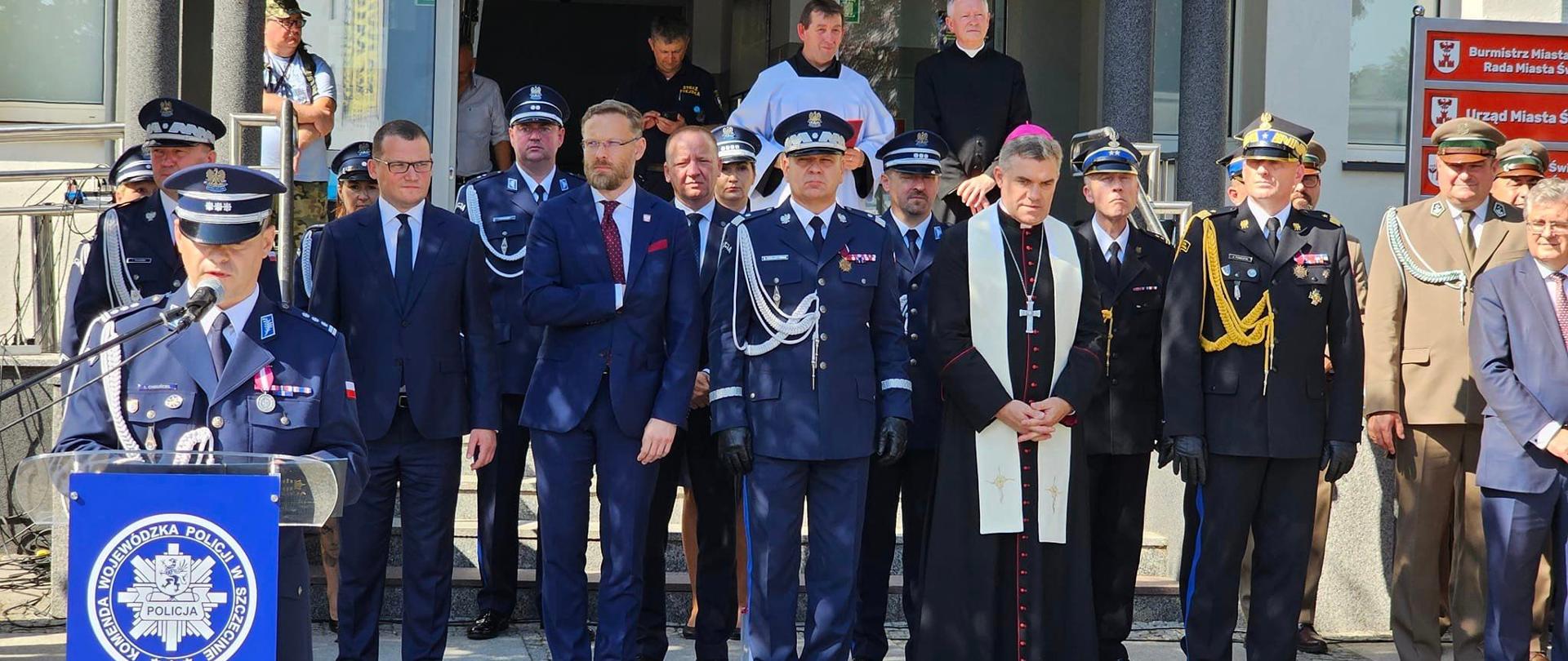 Zdjęcie przedstawia zaproszonych gości na Zdjęcie przedstawia dziecko ubrane w mundur strażaka podczas Uroczystość nadania sztandaru dla Komendy Powiatowej policji w Świdwinie