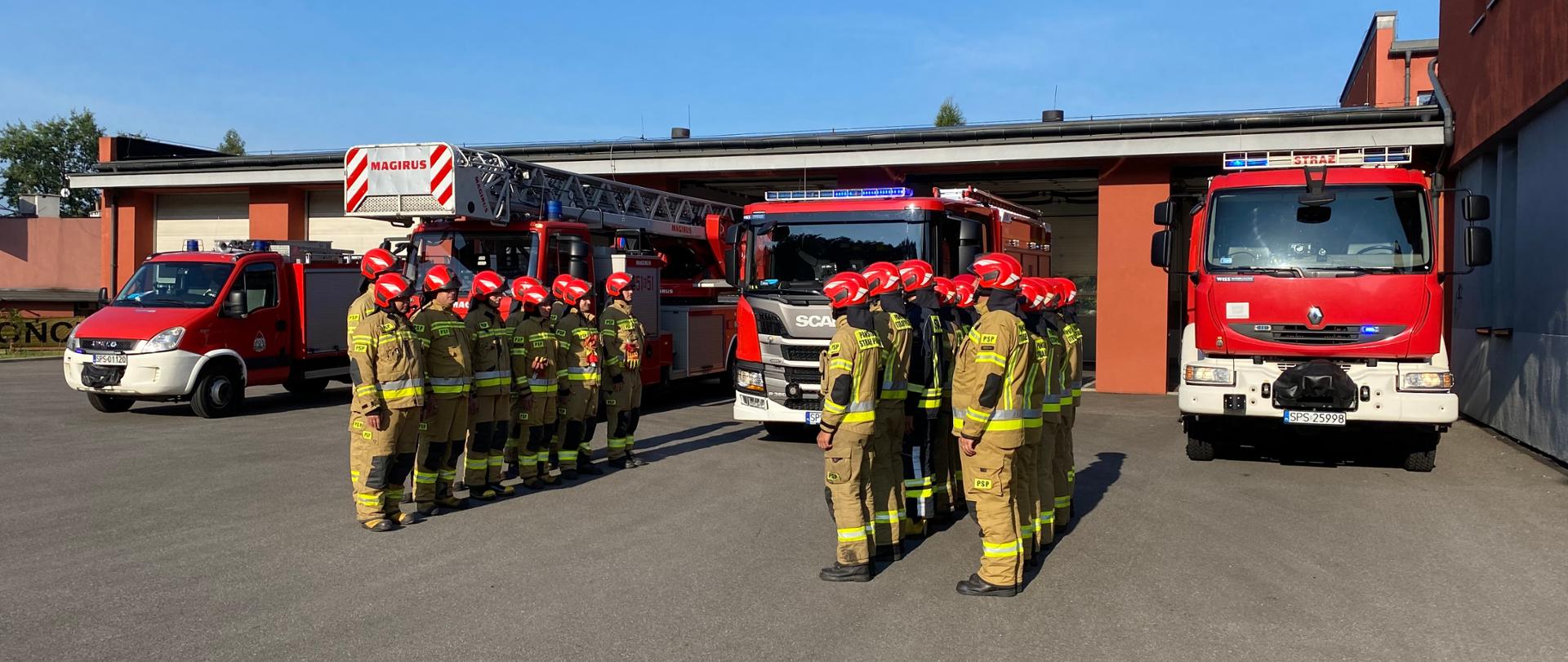 Zdjęcie przedstawia strażaków oraz pojazdy pożarnicze