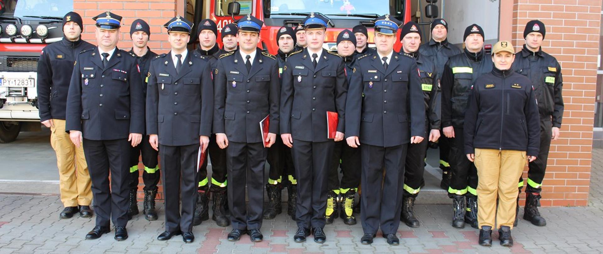 Zdjęcie przedstawia strażaków stojących na uroczystej zbiórce.