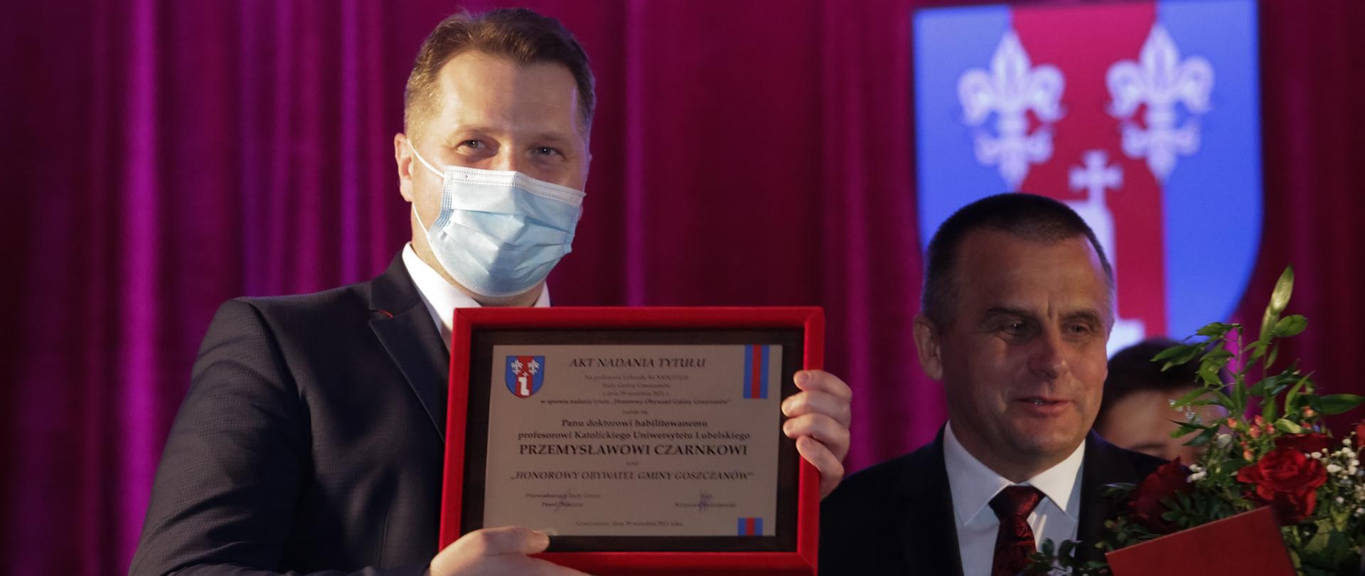 Minister Przemysław Czarnek honorowym obywatelem gminy Goszczanów, minister Przemysław Czarnek prezentuje akt nadania honorowego obywatelstwa gminy Goszczanów.