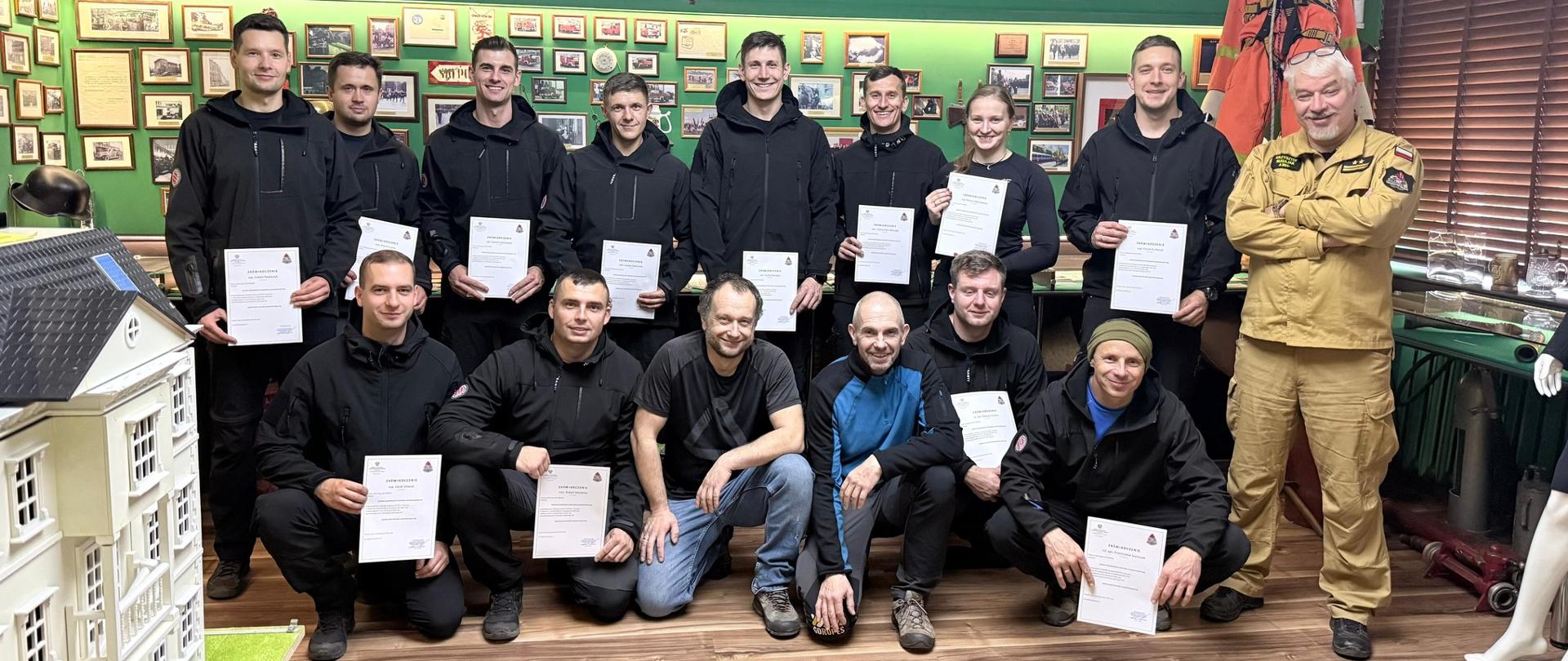 Strażacy z SGRW pozują do zdjęcia trzymając dyplomy.