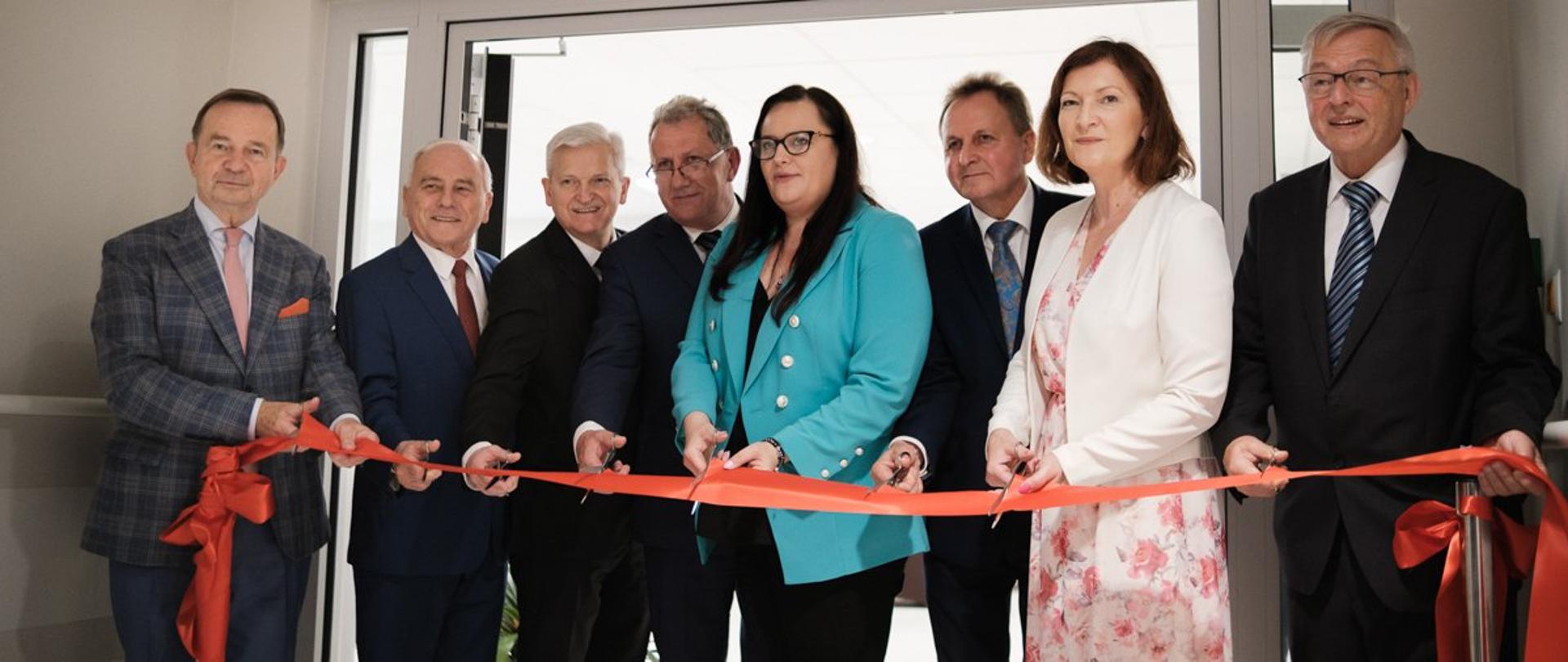 Grupa osób przecina wstęgę