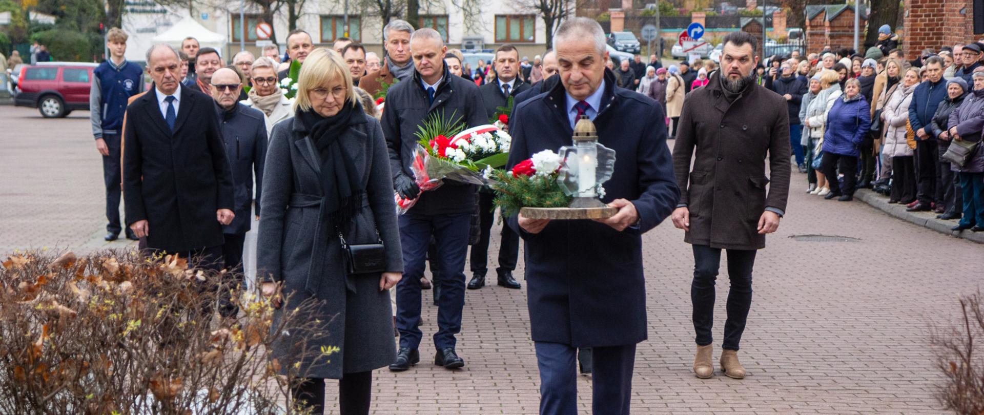 Delegacja ZS CKR w Starym Lubiejewie w osobach dyrektora Andrzeja Sakowicza i kierownik PNZ Marii Dobies składa okolicznościowy stroik pod Dębem Wolności