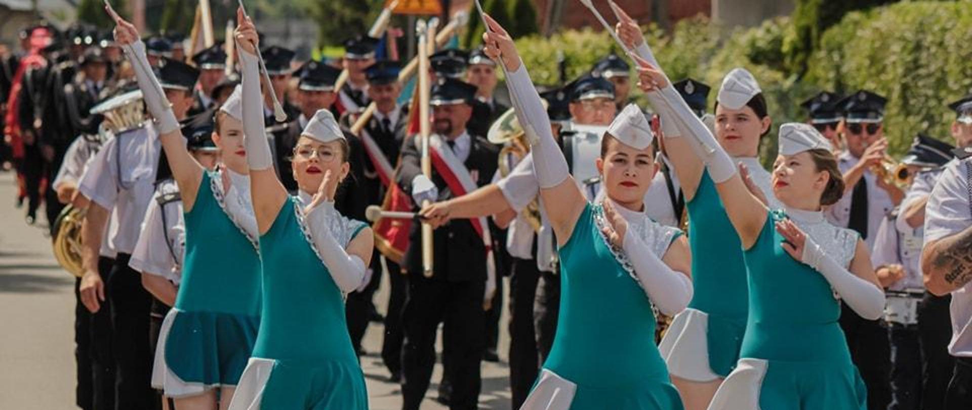 Przemarsz pododdziałów na miejsce uroczystości prowadzonych przez Orkiestrę Dętą OSP Płośnica
