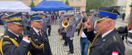 Zdjęcie przedstawia Zastępcę Komendanta Głównego Państwowej Straży Pożarnej nadbrygadiera Adama Koniecznego, Komendanta Powiatowego Państwowej Straży Pożarnej w Lwówku Śląskim starszego brygadiera Mariusza Mróz oraz Dowódcę Jednostki Ratowniczo-Gaśniczej Państwowej Straży Pożarnej w Lwówku Śląskim starszego kapitana Roberta Dulińskiego podczas ceremonii przekazania średniego samochodu ratowniczo-gaśniczego. 
