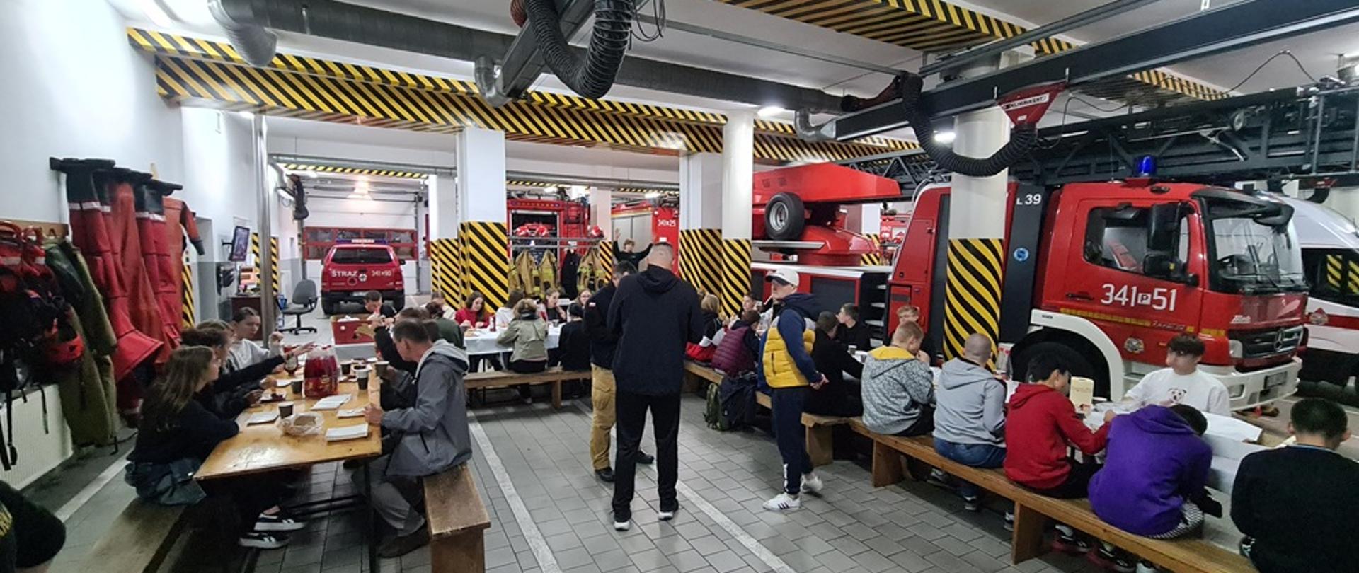 Grupa uczniów w garażu PSP.